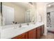 Bathroom featuring a double sink vanity with a large mirror and wood cabinets at 5331 N Pajaro Ct, Litchfield Park, AZ 85340