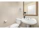 Cozy bathroom featuring a toilet, pedestal sink, and a framed mirror at 5331 N Pajaro Ct, Litchfield Park, AZ 85340