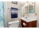 Bathroom featuring a toilet, a cherry-wood vanity, and a mirror at 5331 N Pajaro Ct, Litchfield Park, AZ 85340