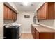 Laundry room with dark wood cabinets, neutral walls, and tile flooring at 5331 N Pajaro Ct, Litchfield Park, AZ 85340