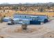 Aerial view of property with home, outbuildings, fenced area, and desert scenery on a sunny day at 53974 W Barrel Rd, Maricopa, AZ 85139