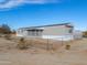 Exterior view of a single-story home featuring a porch, fencing, and desert landscaping at 53974 W Barrel Rd, Maricopa, AZ 85139