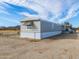 Exterior of home on a sunny day under a partly cloudy sky behind a chain link fence at 53974 W Barrel Rd, Maricopa, AZ 85139