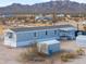 Aerial view of exterior of home on a sunny day under a partly cloudy sky with desert mountains in the background at 53974 W Barrel Rd, Maricopa, AZ 85139