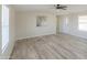 Open living room featuring neutral paint, a ceiling fan, and wood-look floors at 53974 W Barrel Rd, Maricopa, AZ 85139