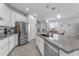 Modern kitchen featuring white cabinets, stainless steel appliances, and a spacious granite countertop island at 5637 S 29Th Pl, Phoenix, AZ 85040