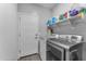 Functional laundry room featuring modern washer and dryer, and shelving for ample storage solutions at 5637 S 29Th Pl, Phoenix, AZ 85040