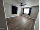 Comfortable bedroom featuring wood-look flooring, a ceiling fan, and a window for natural light at 619 W Cocopah St, Phoenix, AZ 85003