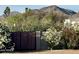 Gated entry with desert landscaping featuring flowers and mountains in the background at 6323 E Gold Dust Ave, Paradise Valley, AZ 85253