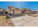 View of a two-story home with a wide driveway and a brick-trimmed, two-car garage in a residential neighborhood at 6405 W Saguaro Dr, Glendale, AZ 85304