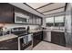 Modern kitchen featuring dark cabinets, stainless steel appliances, and granite countertops at 6405 W Saguaro Dr, Glendale, AZ 85304