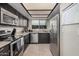 Well-lit kitchen featuring stainless steel appliances, granite countertops, and dark cabinetry at 6405 W Saguaro Dr, Glendale, AZ 85304