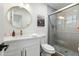 Modern bathroom with tiled shower, white vanity, and elegant round mirror at 6420 N 85Th Pl, Scottsdale, AZ 85250