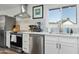 Well-lit kitchen showcasing stainless steel appliances, tile backsplash and white cabinetry at 6420 N 85Th Pl, Scottsdale, AZ 85250