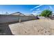 A spacious dirt backyard featuring a concrete block perimeter wall, offering privacy for outdoor activities at 6557 W Puget Ave, Glendale, AZ 85302