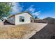 Home's rear exterior showing a spacious dirt backyard, block fence, and stucco walls, providing a blank canvas at 6557 W Puget Ave, Glendale, AZ 85302