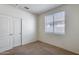 Bedroom featuring neutral walls, carpet, window, and closet, providing ample storage and natural light at 6557 W Puget Ave, Glendale, AZ 85302