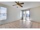 Sunny bedroom featuring tile flooring, ceiling fan, and sliding glass door access to the backyard at 6557 W Puget Ave, Glendale, AZ 85302