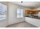 Open dining area with large windows, neutral tile, and adjacent kitchen at 6557 W Puget Ave, Glendale, AZ 85302