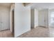 Hallway featuring neutral walls, tile flooring, and multiple doors, enhancing connectivity within the home at 6557 W Puget Ave, Glendale, AZ 85302