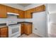 Efficient kitchen setup with white appliances and ample oak cabinet storage at 6557 W Puget Ave, Glendale, AZ 85302