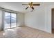 View of the living room featuring tiled flooring, ceiling fan, and sliding glass doors to the backyard at 6557 W Puget Ave, Glendale, AZ 85302