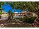 Backyard with pool, covered patio, and desert landscaping under the shade of a tree at 6640 W Honeysuckle Dr, Phoenix, AZ 85083