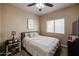 Cozy bedroom featuring a ceiling fan, window, and comfortable decor at 6640 W Honeysuckle Dr, Phoenix, AZ 85083