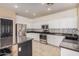 Bright eat-in kitchen boasts white cabinets, stainless steel appliances, and a stylish mosaic backsplash at 6640 W Honeysuckle Dr, Phoenix, AZ 85083