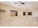 Open-concept living room featuring tile floors, a ceiling fan, neutral walls, and three bright windows at 6640 W Honeysuckle Dr, Phoenix, AZ 85083