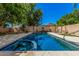 Backyard oasis with a sparkling swimming pool and spa surrounded by lush landscaping at 6640 W Honeysuckle Dr, Phoenix, AZ 85083