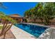 Sparkling blue pool with a stone surround and lush greenery creates a perfect backyard oasis at 6640 W Honeysuckle Dr, Phoenix, AZ 85083
