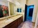 Bathroom featuring double sinks with granite countertop, tile flooring, and a large mirror at 7609 W Whitehorn Trl, Peoria, AZ 85383