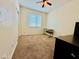 Bright bedroom featuring neutral walls, carpet flooring, ceiling fan, and a large window at 7609 W Whitehorn Trl, Peoria, AZ 85383