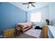 Cozy bedroom with blue accent wall, ceiling fan and pink bedding at 7609 W Whitehorn Trl, Peoria, AZ 85383