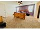 Spacious main bedroom with a large bed, ceiling fan, carpet flooring, and natural light from the window at 7609 W Whitehorn Trl, Peoria, AZ 85383