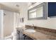 Bright bathroom featuring a dark vanity, granite countertops, and a shower and tub combo at 7830 E Park View Dr, Mesa, AZ 85208