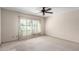 A neutral bedroom featuring a ceiling fan and sliding glass doors at 7830 E Park View Dr, Mesa, AZ 85208