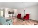 Living room with tile flooring, red and green arm chairs, with a view to the kitchen at 7830 E Park View Dr, Mesa, AZ 85208