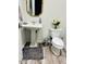 Chic powder room with pedestal sink, decorative mirror, and wood-look flooring at 804 W Village Pkwy, Litchfield Park, AZ 85340