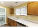 Well-lit kitchen featuring wood cabinets, stainless dishwasher, and bright countertops at 8434 E Natal Cir, Mesa, AZ 85209