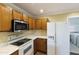 Kitchen view with wooden cabinets, white countertops, and stainless steel microwave above stove at 8434 E Natal Cir, Mesa, AZ 85209