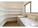 Bright laundry room featuring tile floors, window for natural light, and ample shelving for organized storage at 8434 E Natal Cir, Mesa, AZ 85209