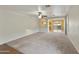 Spacious carpeted living room featuring a ceiling fan and arched doorway to dining at 8434 E Natal Cir, Mesa, AZ 85209