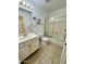 Bathroom with neutral tile, vanity with gold fixtures, and a shower-tub combo with sliding doors at 8536 W Rockwood Dr, Peoria, AZ 85382