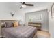 Comfortable bedroom featuring a wood frame bed, ceiling fan, a large window, and closet space at 8602 E Mitchell Dr, Scottsdale, AZ 85251