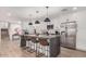 Open-concept kitchen with white cabinets, a large island, stainless steel appliances and eat-in bar at 8602 E Mitchell Dr, Scottsdale, AZ 85251