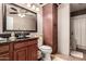 A bathroom featuring a dark granite countertop, dark cabinetry, and decorative tile floors at 8621 W Via Montoya Dr, Peoria, AZ 85383