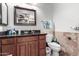 Cozy powder room featuring dark wood cabinetry, and a granite countertop sink at 8621 W Via Montoya Dr, Peoria, AZ 85383