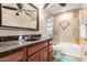 Bathroom featuring a granite vanity top and custom tiled shower/tub at 8621 W Via Montoya Dr, Peoria, AZ 85383